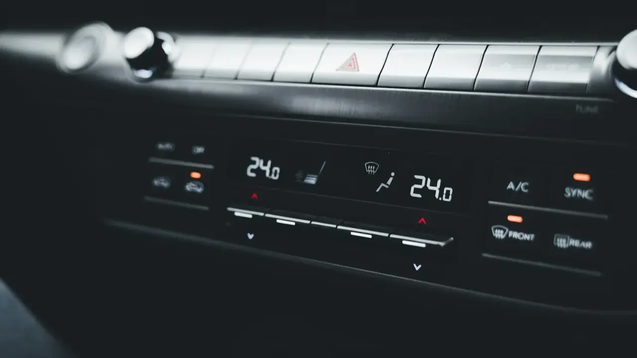 Panel klimatyzacji samochodowej z wyświetlaczem temperatury 24.0. Objawy uszkodzony skraplacz klimatyzacji mogą być trudne do zauważenia na pierwszy rzut oka.