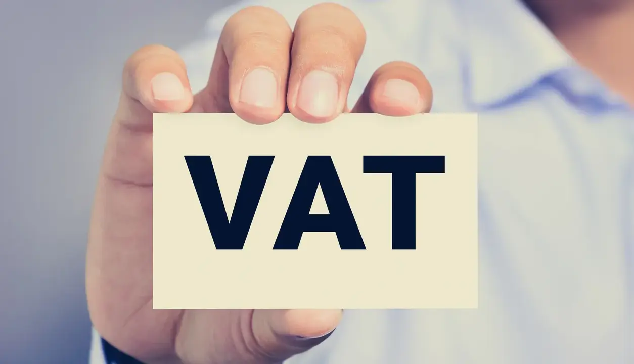 Dłoń trzyma kartkę z napisem VAT. Kluczowe jest zrozumienie proporcji VAT w biznesie.