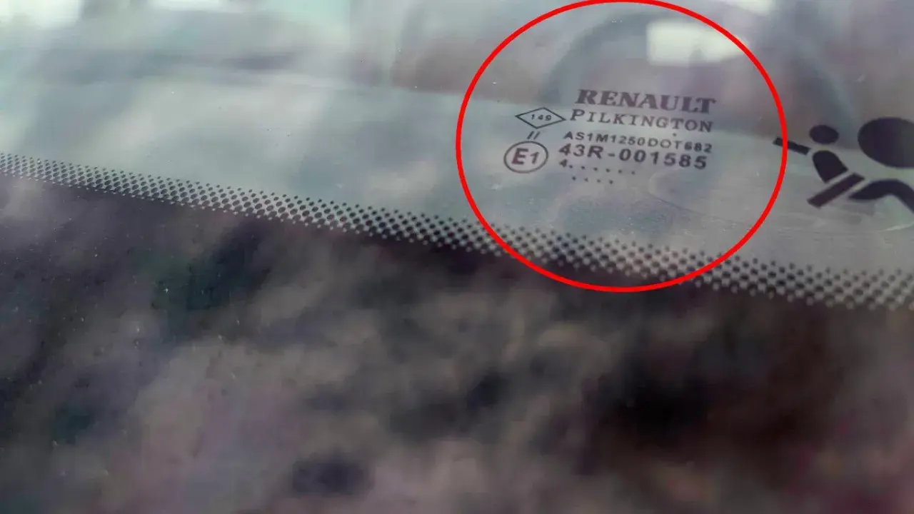 Oznaczenia na szybach samochodowych Renault Pilkington. Widoczne symbole i kody homologacji na przedniej szybie.