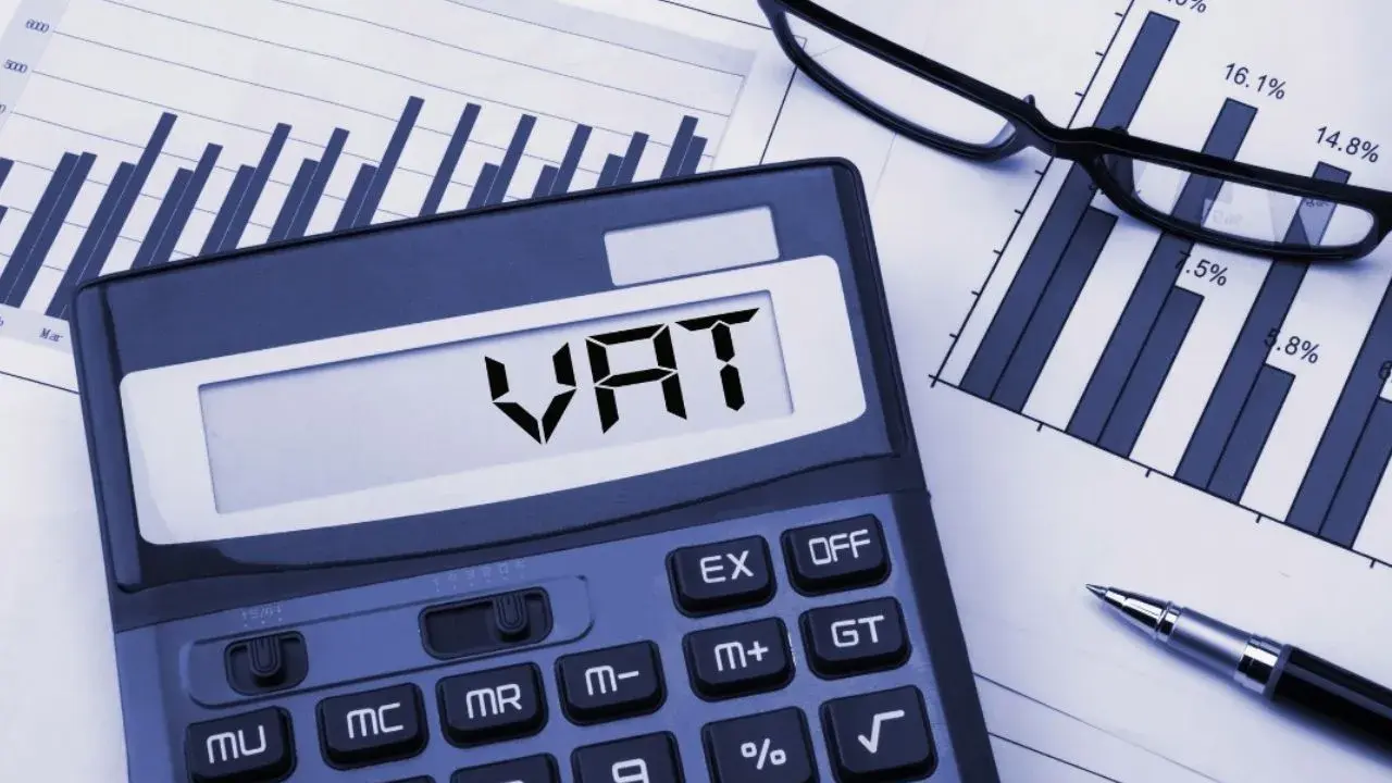 Kalkulator z napisem VAT, wykresy i okulary. Planowanie finansowe i limit vat 2026.