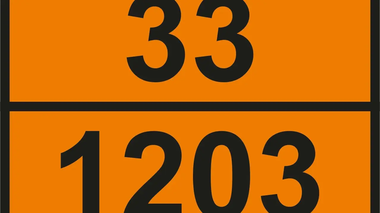 Pomarańczowa tablica z czarnymi numerami: 33 na górze i 1203 na dole. Te numery UN wskazują na niebezpieczny ładunek.