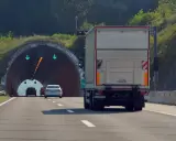 Ciężarówka zbliża się do tunelu. W tunelu widać zielone strzałki, co oznacza, że cemt jest otwarty.