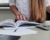 Kobieta przegląda instrukcję wysyłkową wzór, obok leży laptop.