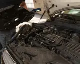 Mechanik sprawdza silnik, który mógł przegrzać się z powodu wysokiej temperatury.
