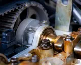 Widok na mechanizm rozrządu silnika samochodowego. Zębatka i pasek rozrządu, elementy wałka rozrządu. Luźny łańcuch rozrządu objawy mogą być groźne.