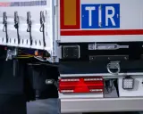 TIR to duża ciężarówka, która przewozi towary. Na zdjęciu widać tył naczepy z charakterystycznym znakiem TIR.