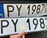Dwie polskie tablice rejestracyjne, jedna nad drugą. Na górnej widać nalepkę z hologramem. Dolna jest nowa, z taśmą klejącą.