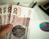 Dłoń trzyma kilka banknotów po 20 złotych. Kiedy mpp, warto mieć oszczędności.