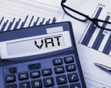 Kalkulator z napisem VAT, wykresy i okulary. Planowanie finansowe i limit vat 2026.