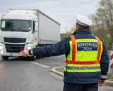 Policjant kieruje ruchem, wskazując drogę białej ciężarówce. Przewoźnik jest obowiązany przestrzegać jego poleceń.