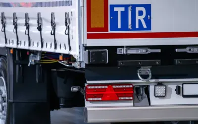 TIR to duża ciężarówka, która przewozi towary. Na zdjęciu widać tył naczepy z charakterystycznym znakiem TIR.