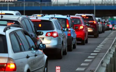 Korki na drodze, typowe dla wakacyjnych wyjazdów. Długi sznur samochodów, czerwone światła stopu.