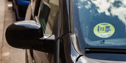 Naklejka z numerem "B" na szybie samochodu. Czy wszystkie szyby w samochodzie mają ten sam numer?