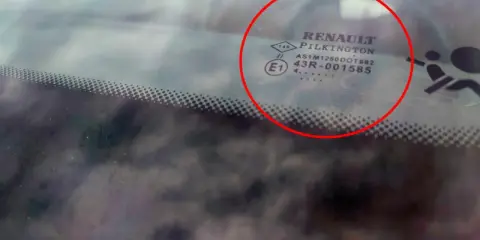 Oznaczenia na szybach samochodowych Renault Pilkington. Widoczne symbole i kody homologacji na przedniej szybie.