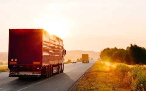 Ciężarówki na drodze o zachodzie słońca. Spedycja to odpowiedzialność, która wymaga dbałości o każdy szczegół.