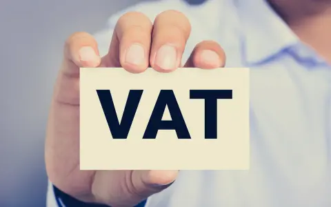 Dłoń trzyma kartkę z napisem VAT. Kluczowe jest zrozumienie proporcji VAT w biznesie.