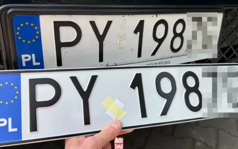 Dwie polskie tablice rejestracyjne, jedna nad drugą. Na górnej widać nalepkę z hologramem. Dolna jest nowa, z taśmą klejącą.