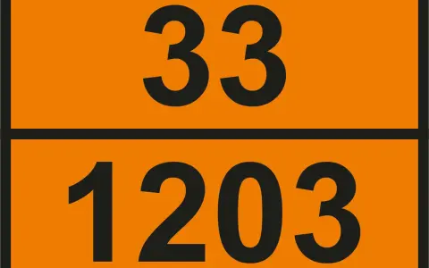Pomarańczowa tablica z czarnymi numerami: 33 na górze i 1203 na dole. Te numery UN wskazują na niebezpieczny ładunek.
