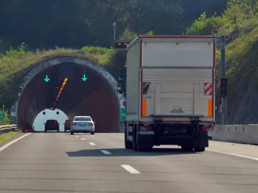 Ciężarówka zbliża się do tunelu. W tunelu widać zielone strzałki, co oznacza, że cemt jest otwarty.