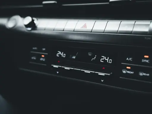 Panel klimatyzacji samochodowej z wyświetlaczem temperatury 24.0. Objawy uszkodzony skraplacz klimatyzacji mogą być trudne do zauważenia na pierwszy rzut oka.