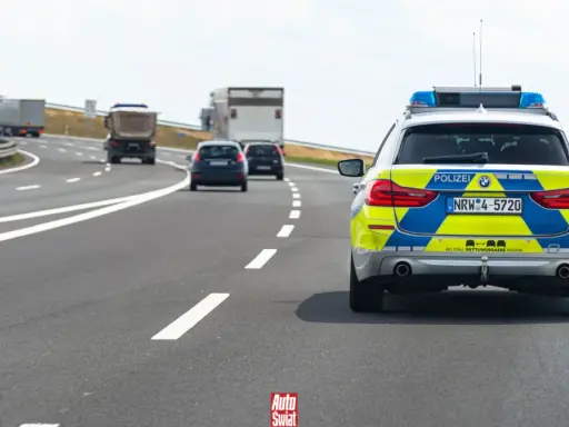 Niemieckie autostrady bez limitu, gdzie policja pilnuje porządku. Na drodze radiowóz i inne pojazdy.