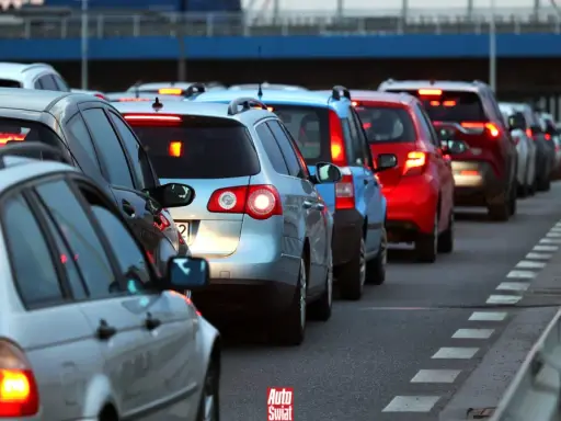 Korki na drodze, typowe dla wakacyjnych wyjazdów. Długi sznur samochodów, czerwone światła stopu.