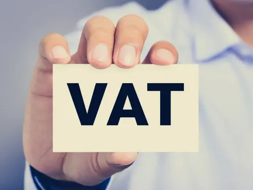 Dłoń trzyma kartkę z napisem VAT. Kluczowe jest zrozumienie proporcji VAT w biznesie.