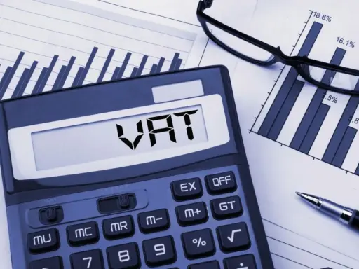 Kalkulator z napisem VAT, wykresy i okulary. Planowanie finansowe i limit vat 2026.