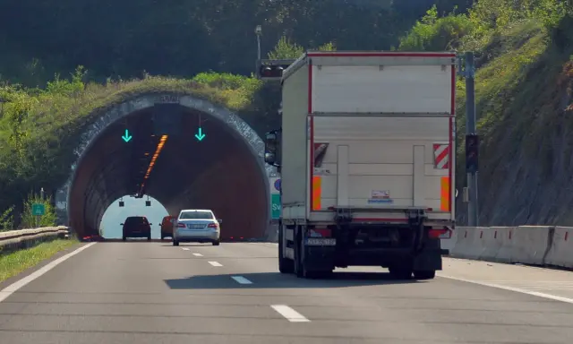 Ciężarówka zbliża się do tunelu. W tunelu widać zielone strzałki, co oznacza, że cemt jest otwarty.