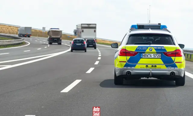 Niemieckie autostrady bez limitu, gdzie policja pilnuje porządku. Na drodze radiowóz i inne pojazdy.