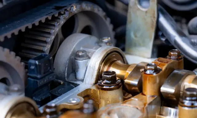 Widok na mechanizm rozrządu silnika samochodowego. Zębatka i pasek rozrządu, elementy wałka rozrządu. Luźny łańcuch rozrządu objawy mogą być groźne.