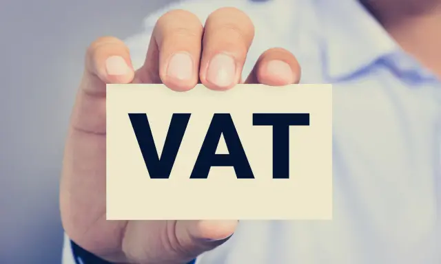 Dłoń trzyma kartkę z napisem VAT. Kluczowe jest zrozumienie proporcji VAT w biznesie.