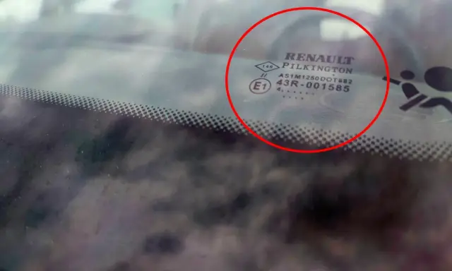 Oznaczenia na szybach samochodowych Renault Pilkington. Widoczne symbole i kody homologacji na przedniej szybie.