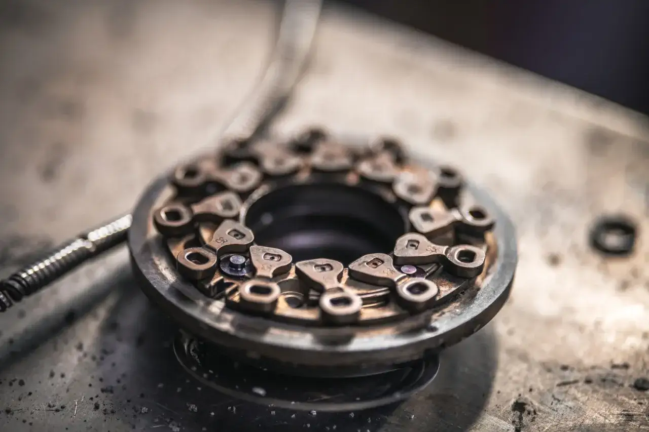 Detale budowy turbosprężarki ze zmienną geometrią. Metalowe elementy tworzą skomplikowany mechanizm.