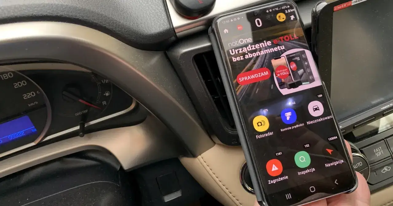 Telefon z aplikacją notiOne e-TOLL w samochodzie. Czy Yanosik jest legalny? Aplikacja pokazuje fotoradary i inne zagrożenia na drodze.