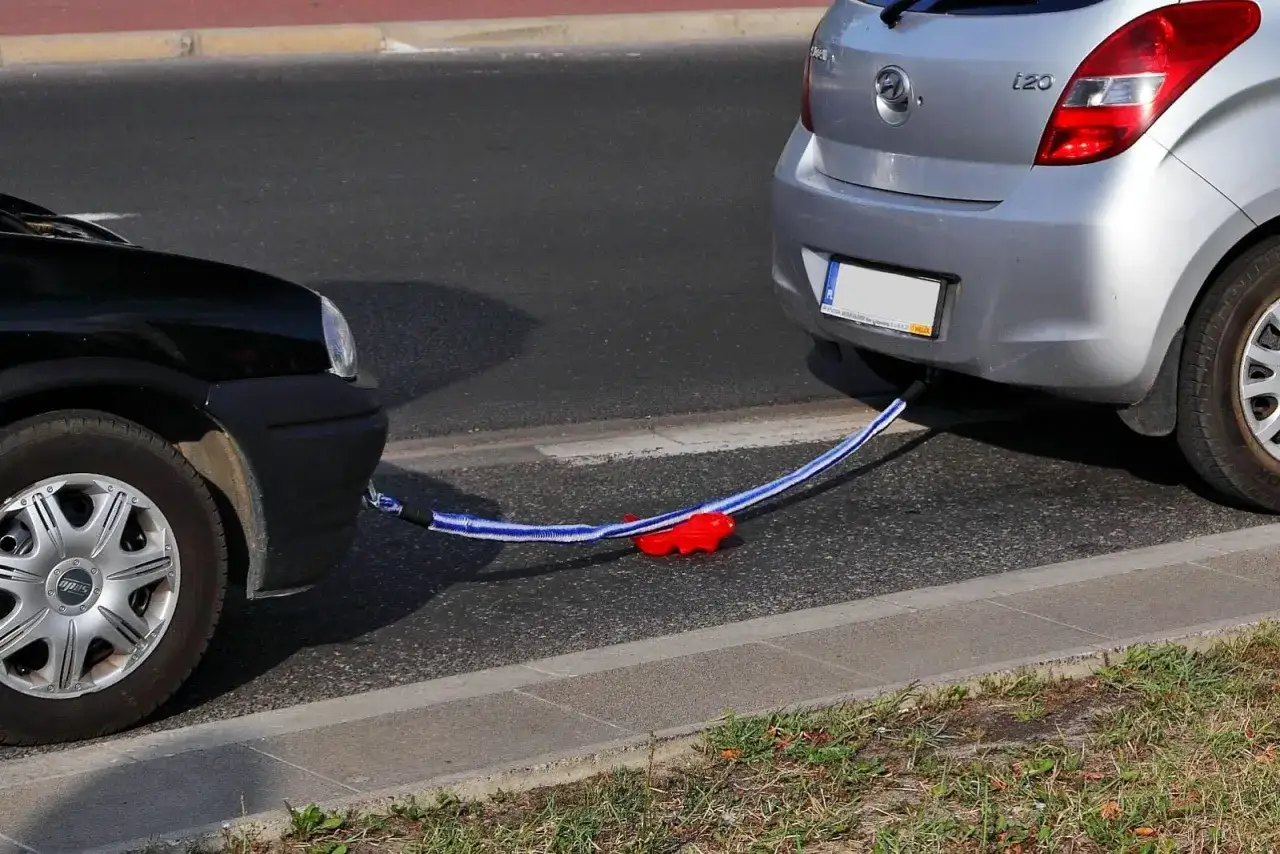 Dwa samochody połączone liną holowniczą. Czy można holować auto bez przeglądu? Pytanie pozostaje otwarte.
