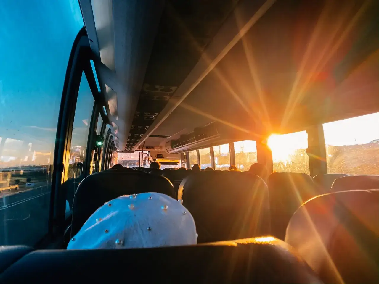 Zach&oacute;d słońca rozświetla wnętrze autokaru, tworząc magiczną atmosferę podczas transportu okazjonalnego.