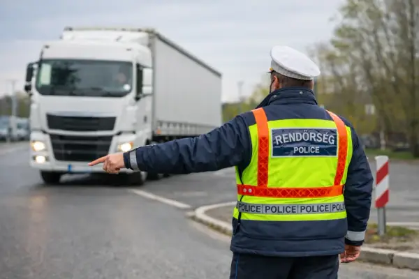 Policjant kieruje ruchem, wskazując drogę białej ciężarówce. Przewoźnik jest obowiązany przestrzegać jego poleceń.
