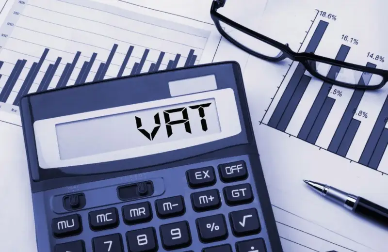 Kalkulator z napisem VAT, wykresy i okulary. Planowanie finansowe i limit vat 2026.